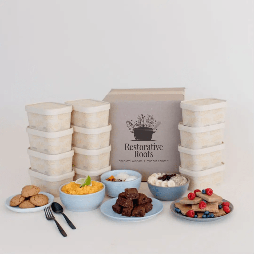 Stacks of food containers with a 'Restorative Roots' sign on a light gray background