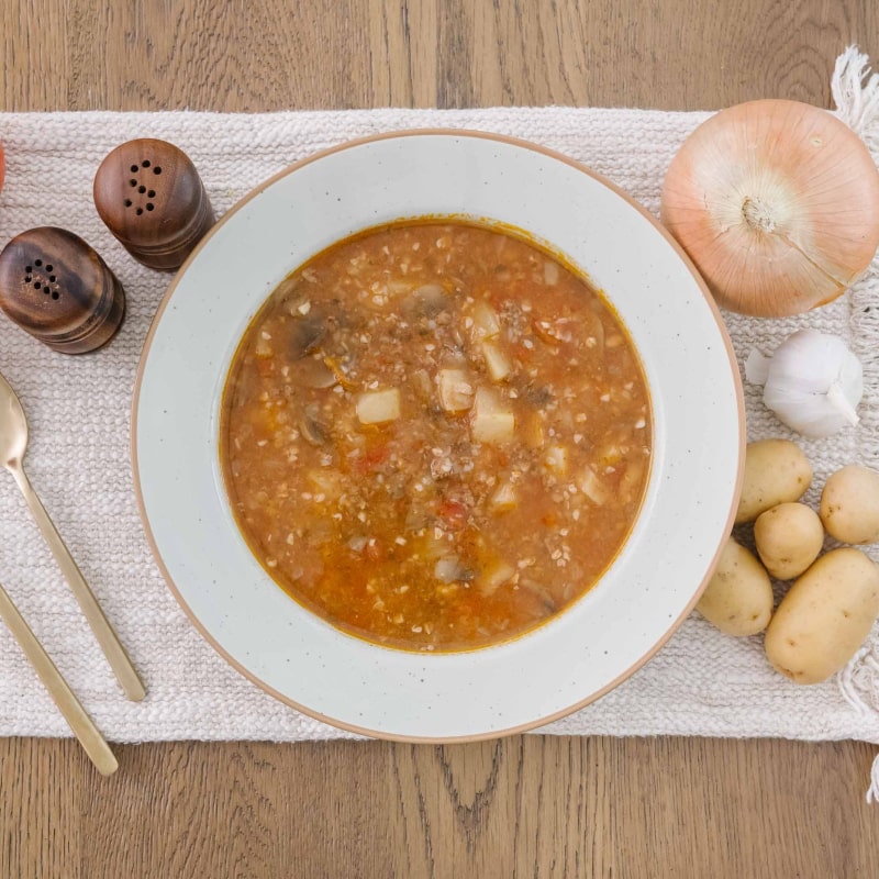 Bowl of high protein meat postpartum stew on a wooden table