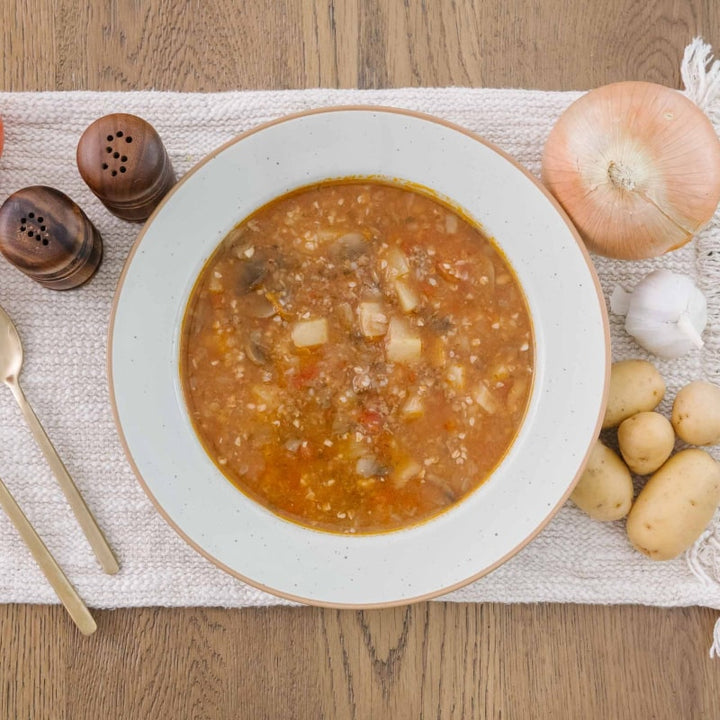 Bowl of high protein meat postpartum stew on a wooden table