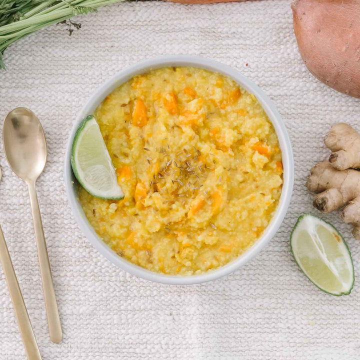 a bowl of yellow kitchari as best food for postpartum that is organic and regenerative and gluten-free