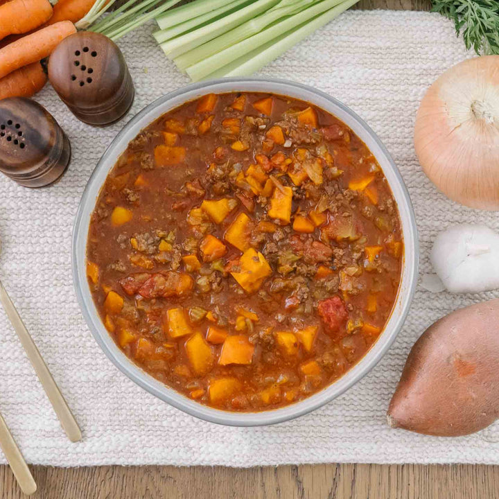 Bowl of soup with carrots, celery, and onions crafted for postpartum nutrition