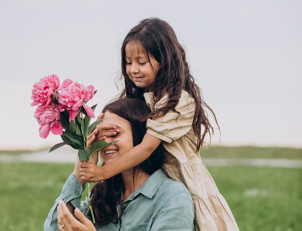 Mother and daughter holding bouquet of flowers