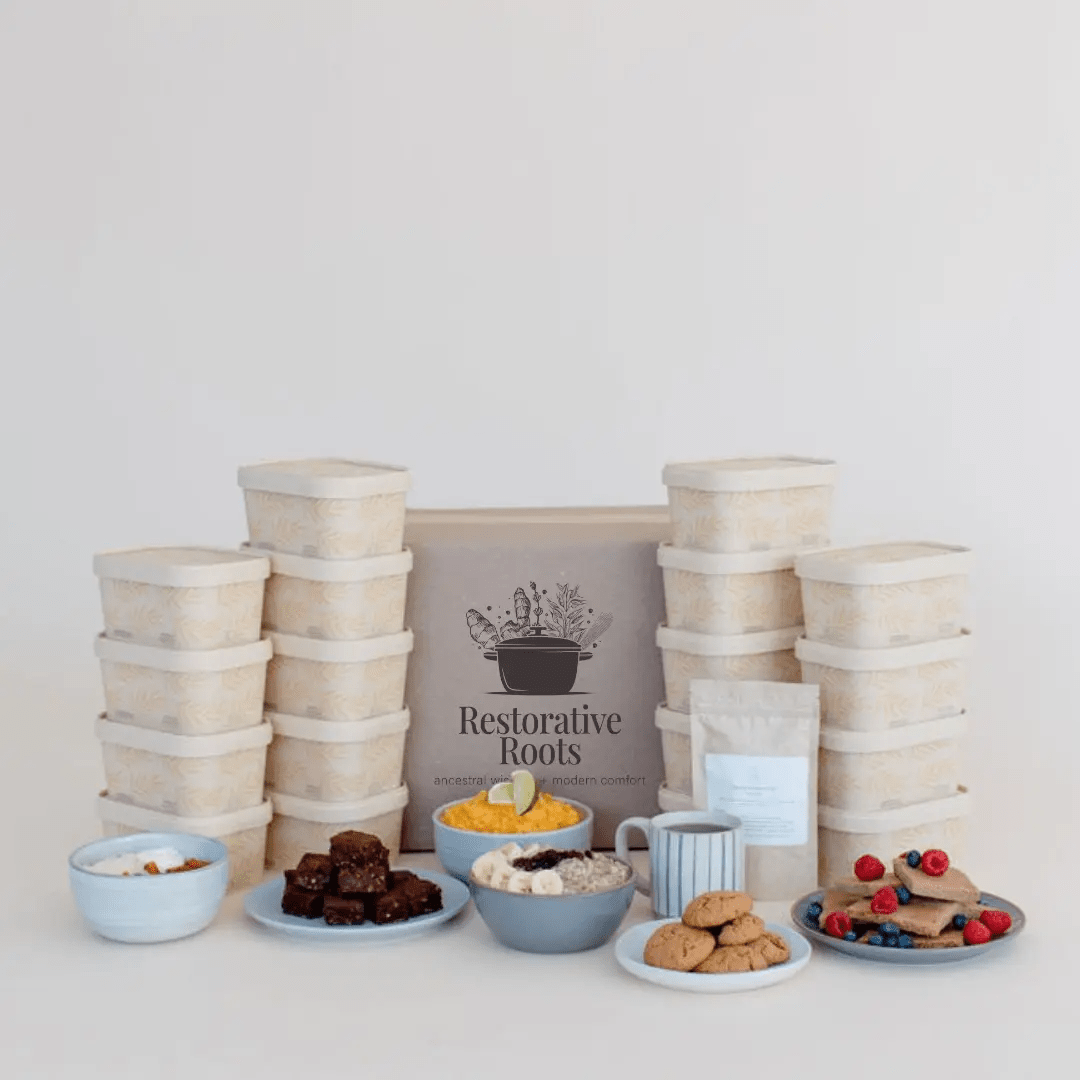 Restorative Roots freezer meal stacks beside bowls of prepared food and dates