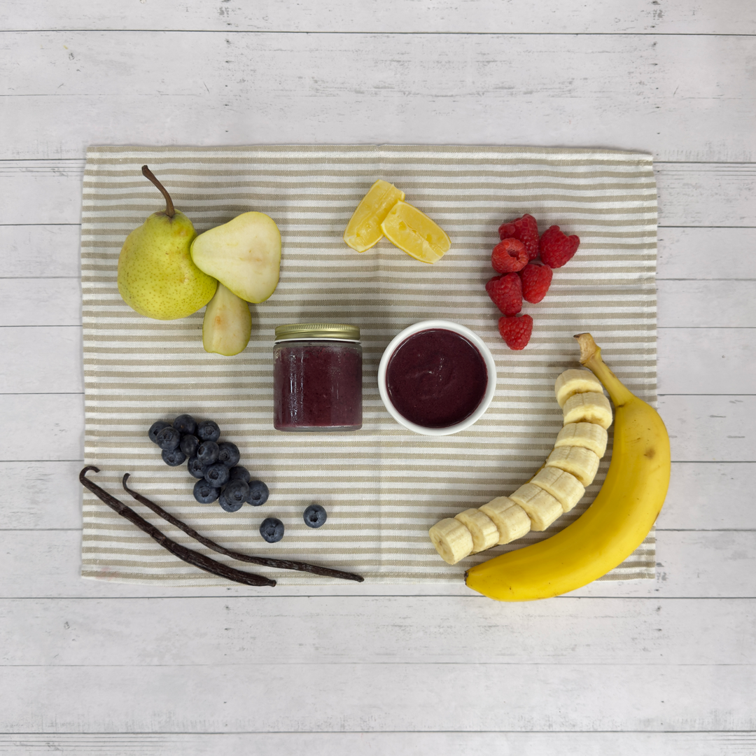 Blueberry puree in a jar and bowl with fresh blueberries, raspberries, banana, and pear