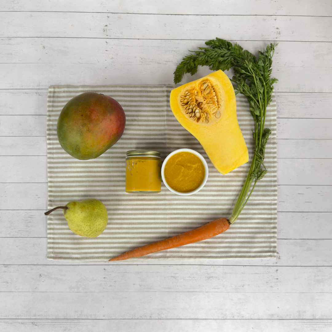 Mango butternut squash puree with fresh mango, squash, carrot, and pear on striped linen