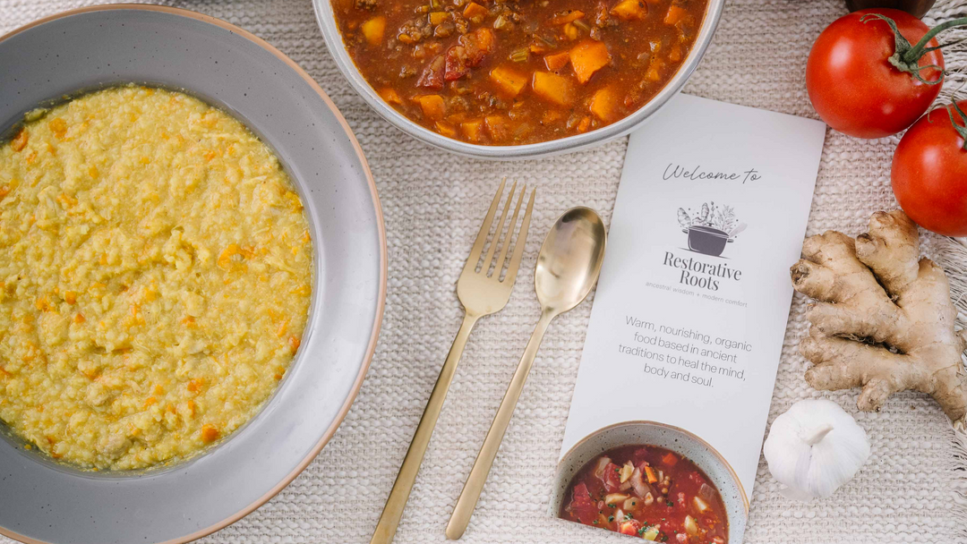 Golden congee beside a Restorative Roots recipe card with gold flatware