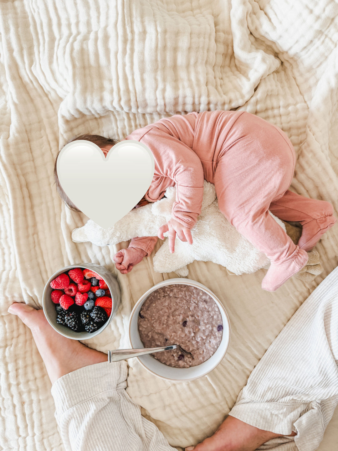Looking down at baby with bowl of berries and oatmeal 