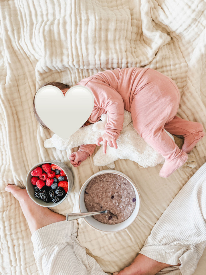 Looking down at baby with bowl of berries and oatmeal 